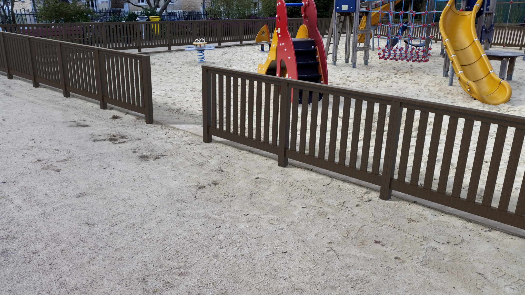 Aire de jeux vide avec toboggan et sable.