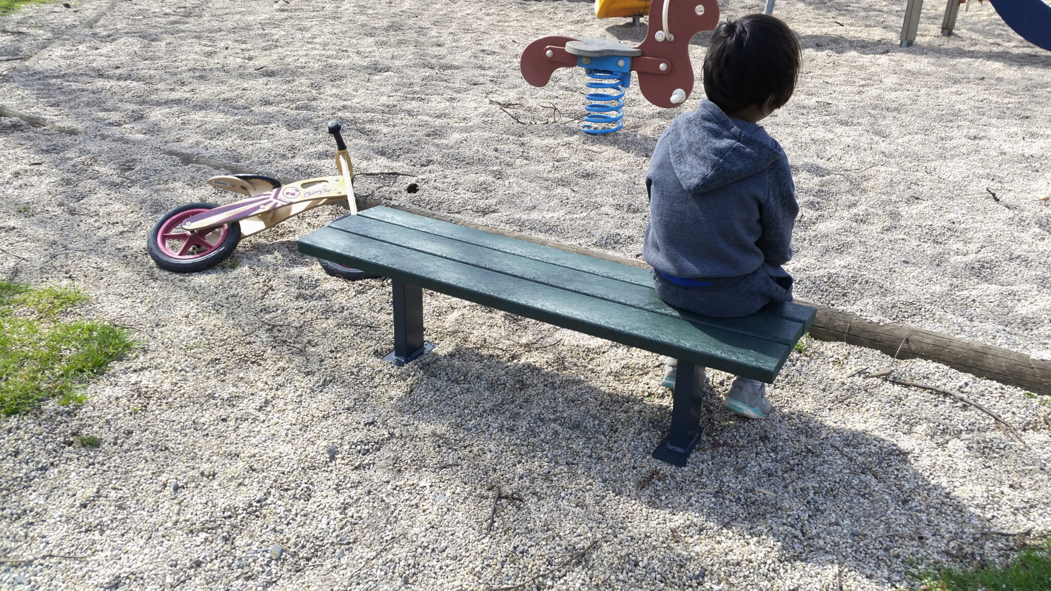Enfant sur un banc dans un parc de jeux