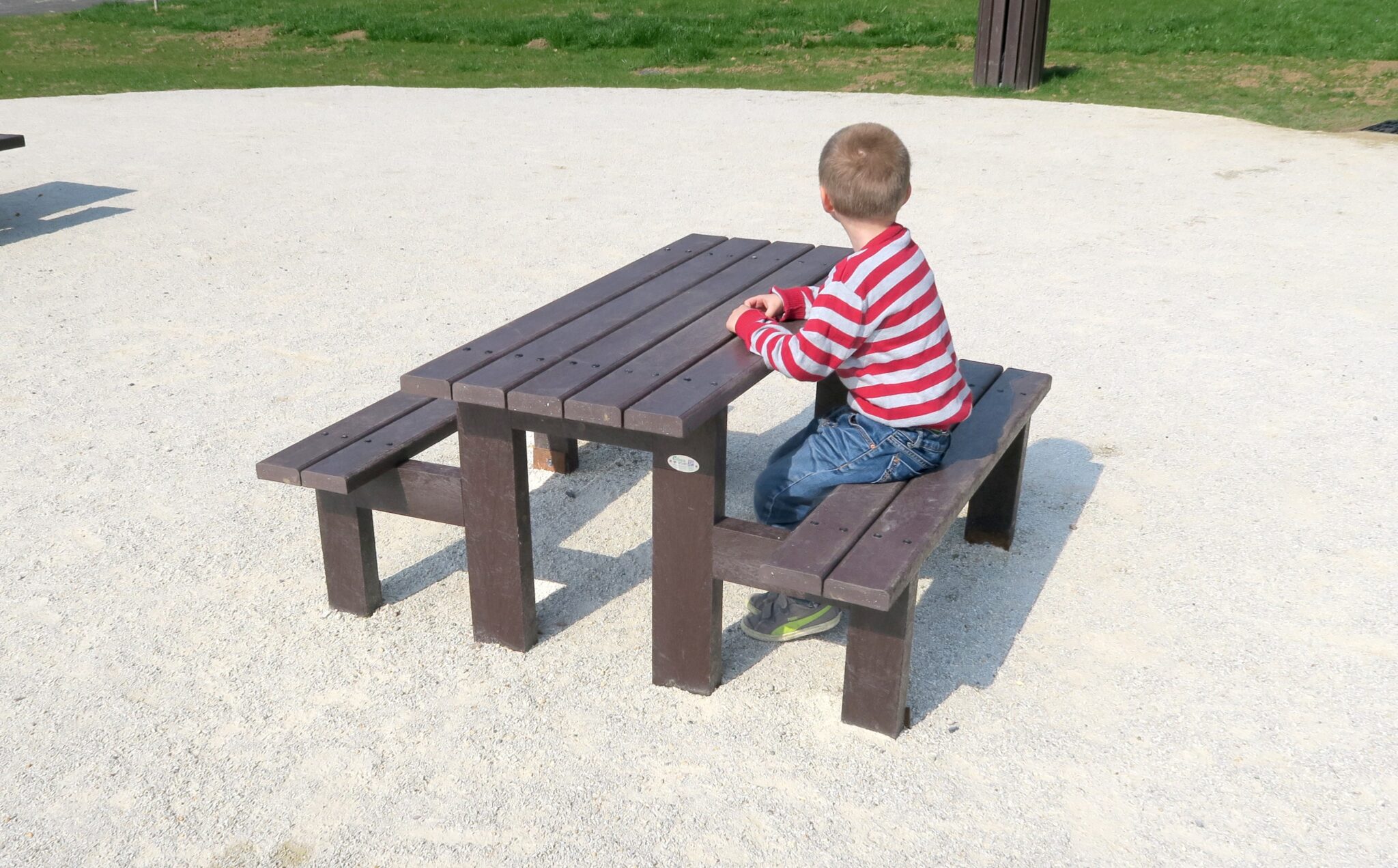 Enfant seul sur un banc de parc.
